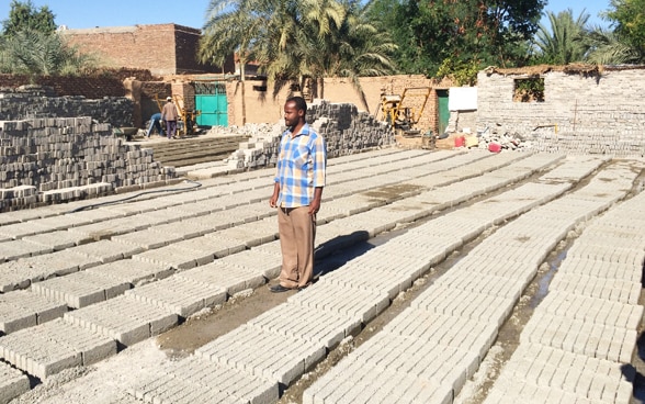 Un villageois participe à la production de briques destinées à la rénovation des canaux d’irrigation. © DDC