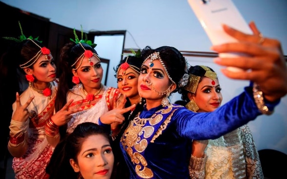 Dancers are taking photos with their mobile phones before going on stage for their performance in Dhaka, Bangladesh