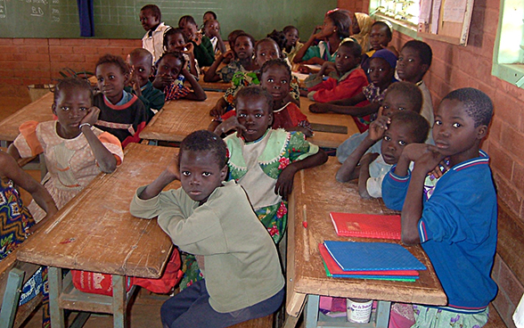 Des enfants, assis sur leurs bancs, suivent une leçon au Burkina Faso.
