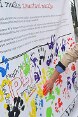 Un jeune pose sa main enduite de peinture sur une charte collective.