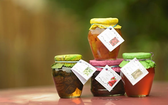 Four jars containing different kinds of preserves.