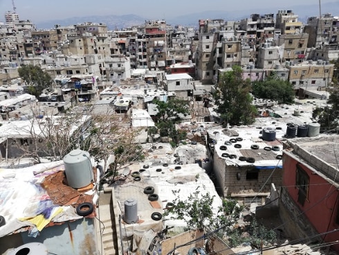 aerial view of the school in Hay el Gharbé with water tanks and tyres on the roofs of the houses. 