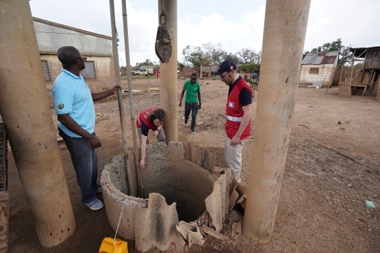 Eine Expertin und einen Expert des SKH und lokale Partner begutachten Brunnen 