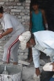 A Roma family building the walls of their house.