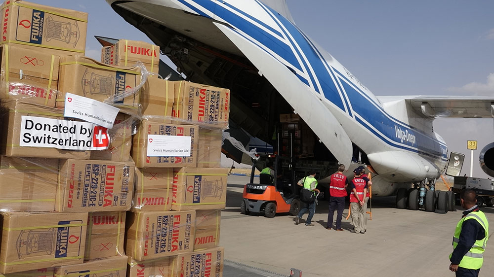 Scatoloni dell’Aiuto umanitario svizzero vengono scaricati da un aereo cargo. 
