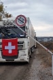 Ein Soldat öffnet den Schlagbaum und gibt den Weg frei für einen Lastwagen der Humanitären Hilfe der Schweiz.