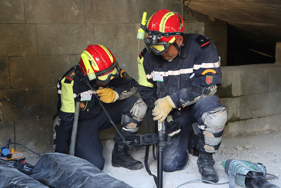 Dos socorristas se entrenan en el interior de un edificio en ruinas con un aparato de búsqueda. 