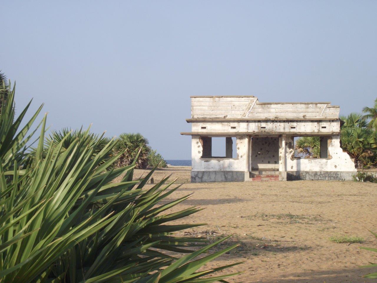 Immagine di una casa in riva all’oceano crivellata di colpi.