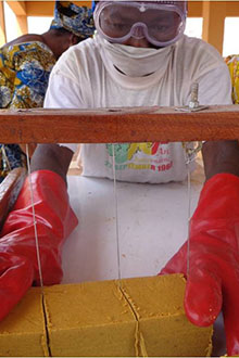A trainee learning to cut blocks of soap.