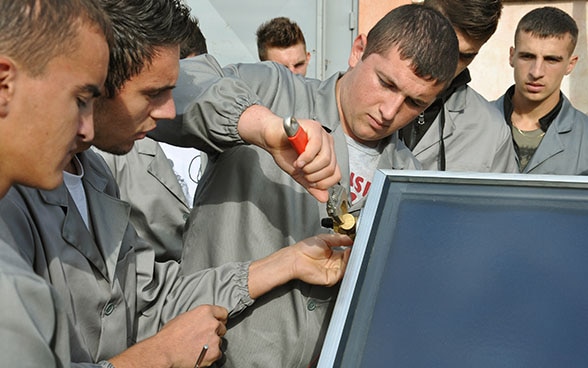 Des apprentis en Albanie travaillent sur une machine thermo-hydraulique.