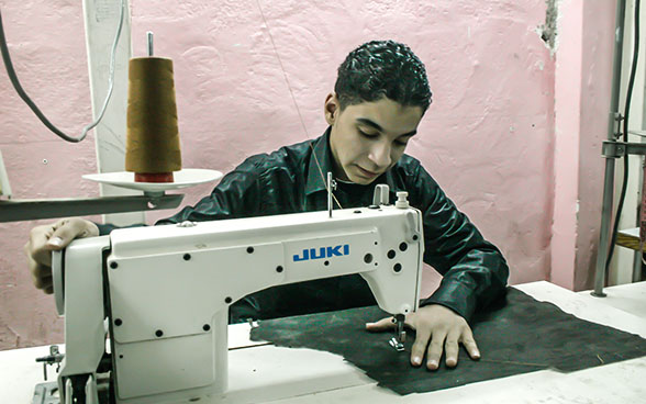 An apprentice sewing fabric with a sewing machine