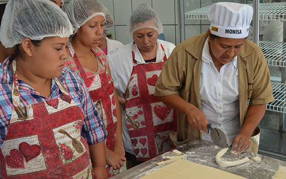 Des apprenties en boulangerie-pâtisserie écoutent les explications d’une instructrices
