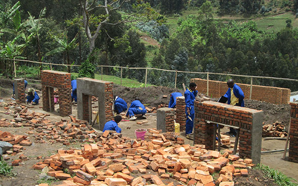 Des apprentis maçons construisent des petits murs comme exercice