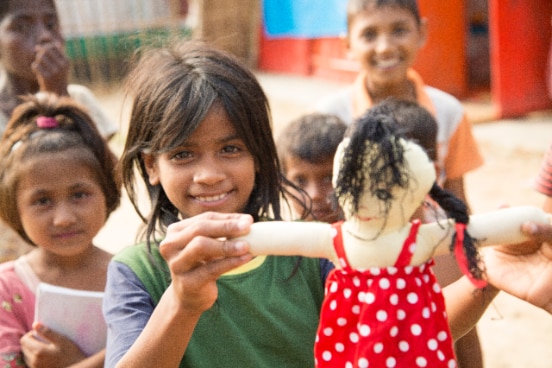 Spielende Rohingya-Kinder mit einer Puppe in einem Flüchtlingslager in Bangladesch
