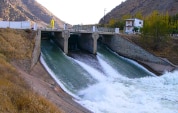 Una massa d’acqua fuoriesce dalle chiuse aperte di una diga di ritenuta.