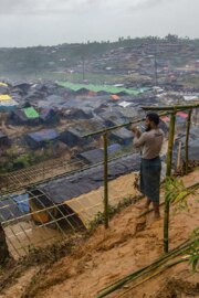 Un uomo costruisce un rifugio in legno per la propria famiglia ai margini del campo profughi a Cox’s Bazar.