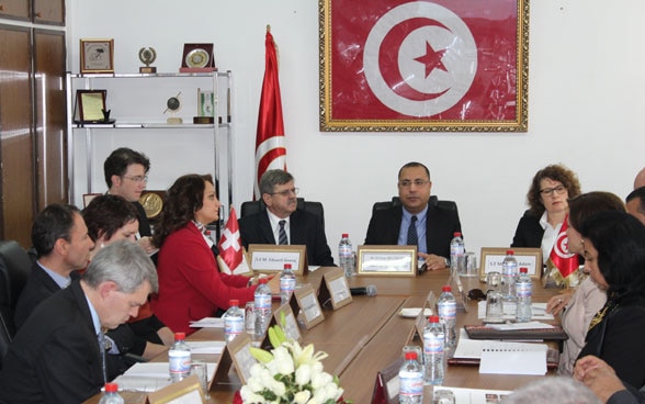 Cittadine e cittadini tunisini discutono durante una riunione.