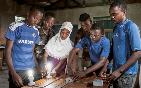 Jugendliche, darunter ein Mädchen, nehmen an einer Elektriker-Berufsbildung in einem Ausbildungszentrum in Tansania teil.