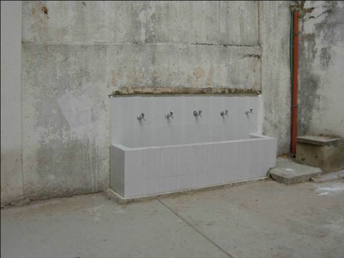 Un lavabo común totalmente reconstruido, con cinco grifos.