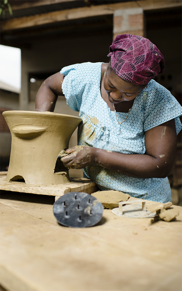 A woman is making a clay oven.