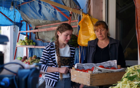 Das Bild zeigt eine Verkäuferin auf dem Markt von Senaki beim Wägen der Tomaten, die Medea und ihr Vater mitgebracht haben.