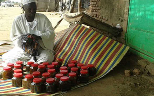 Abdul-Aziz Mohammed Salih from Sudan selling his honey at the market in Bindisi in Darfur. 