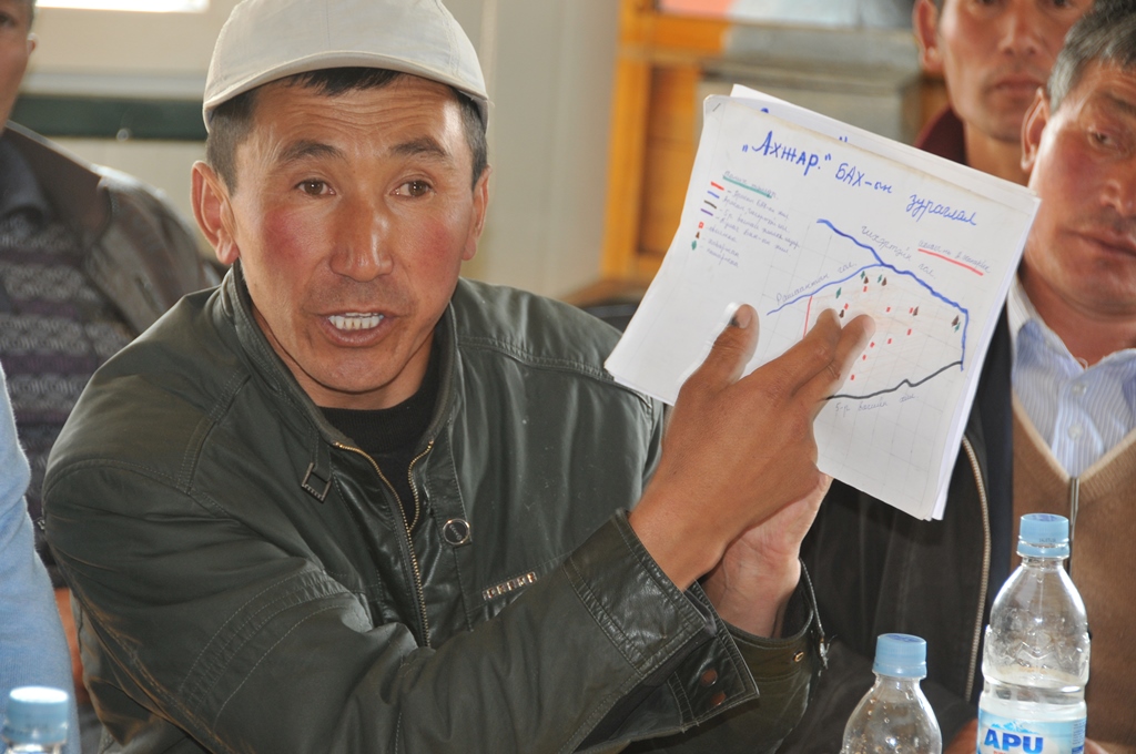 A man shows a rotational grazing plan at a meeting of herders.