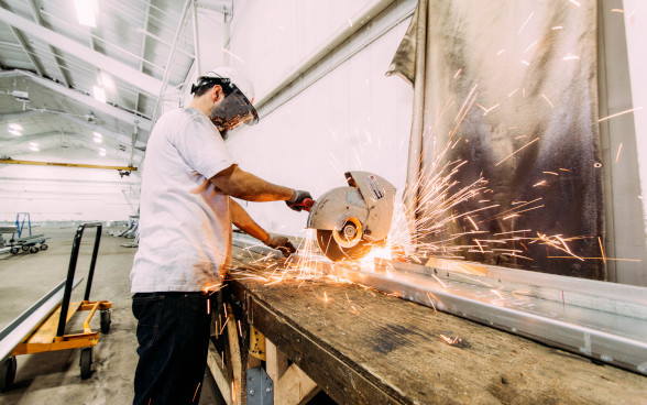 A man cuts metal with a circular saw. A man cuts metal with a circular saw.