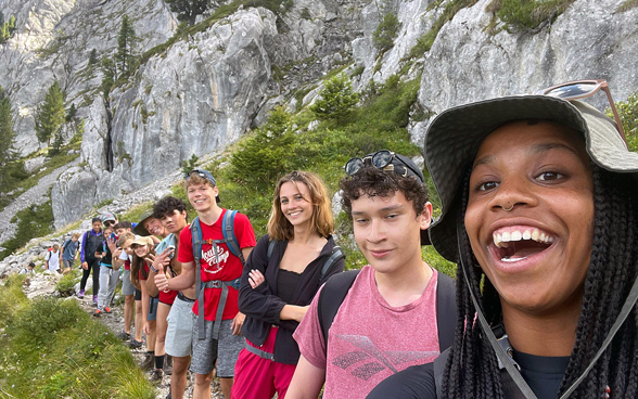 The selfie portrays a group of friends in the mountains.
