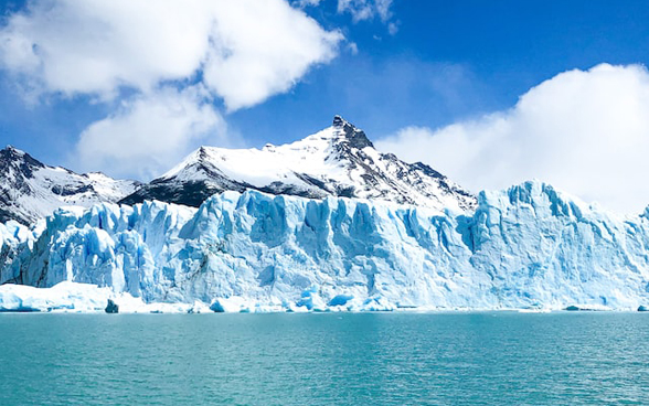 In the picture there is a glacier surrounded by water.