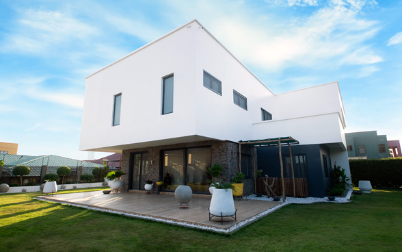 Una casa bianca, moderna, con terrazza e giardino.