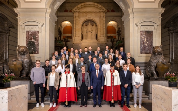 Bundespräsident Ignazio Cassis und Bundesrätin Viola Amherd mit rund 20 Sportlern im Parlamentsgebäude.