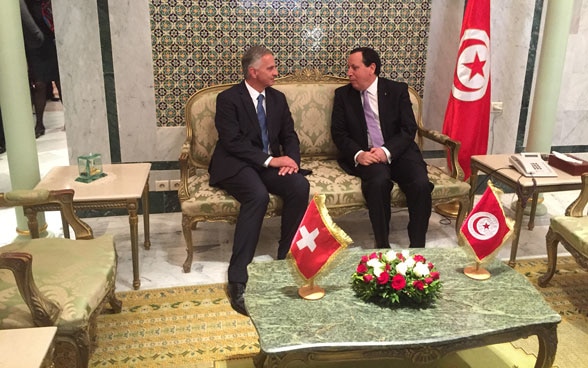 Bundesrat Didier Burkhalter sitzt mit dem tunesischen Aussenminister Khemaies Jhinaoui auf einem Sofa und unterhält sich.