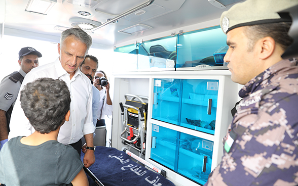 The Federal Councillor talks to a young boy in the ambulance donated by Switzerland to Jordan’s civil defence agency 