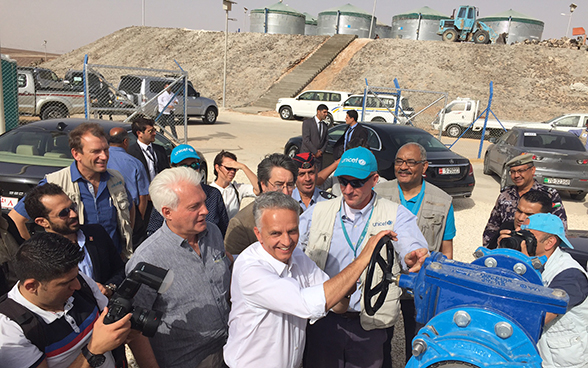 Bundesrat Burkhalter dreht das Rad, mit dem die Trinkwasseranlage in Betrieb gesetzt wird.