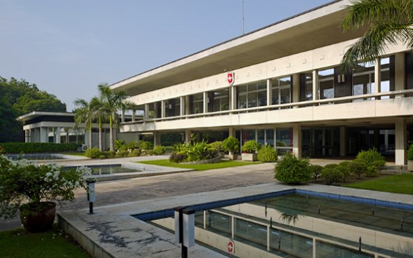 Two-storey embassy building with pools in the foreground.
