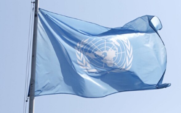 Le drapeau de l’ONU flotte au-dessus du bâtiment du Palais des Nations à Genève. 