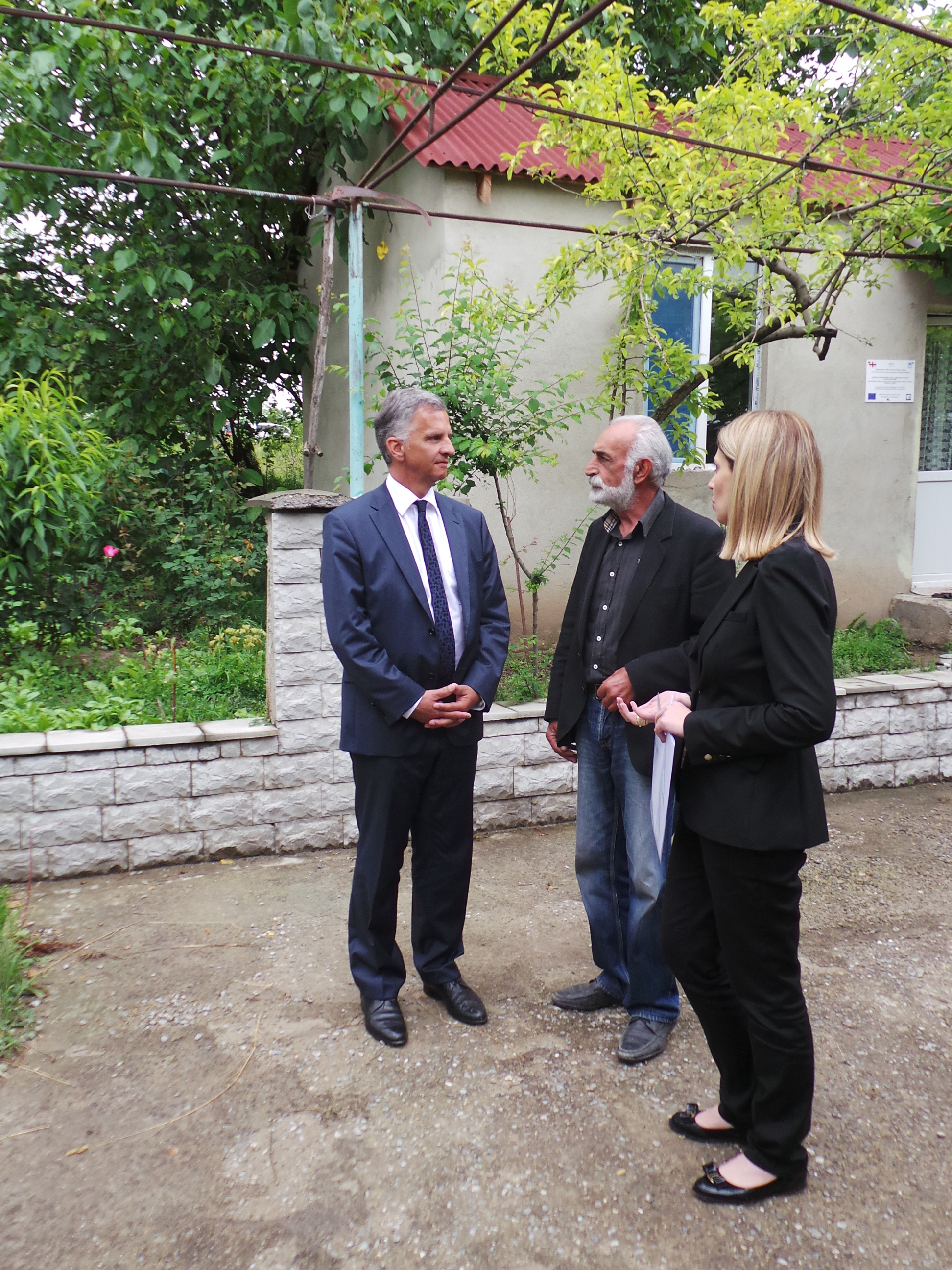 Il presidente della Confederazione Didier Burkhalter parla con il proprietario di una casa distrutta durante la guerra, ricostruita con il sostegno della DSC.