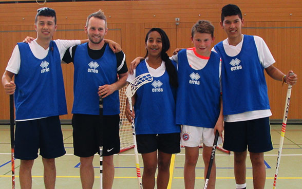 I giovani colombiani posano per la foto con il loro bastone da unihockey in mano. 