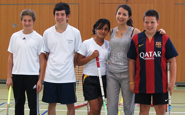 I giovani colombiani posano per la foto con il loro bastone da unihockey in mano. 