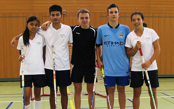 The young Colombians with a stick of unihockey in the hand.