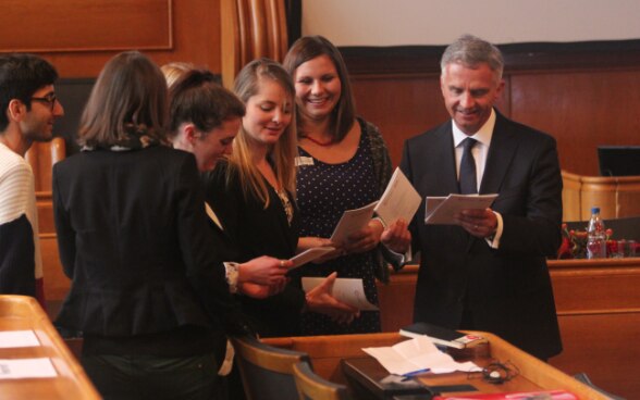 Il presidente della Confederazione Didier Burkhalter si confronta con alcuni giovani nella sala del Gran Consiglio del Cantone di Berna. © Keystone