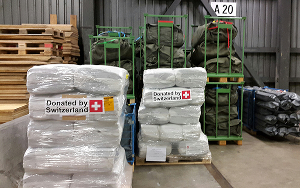 Gestapelte Hilfsgüter der Schweiz für Nepal.