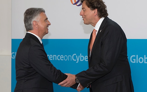 Les ministres des affaires étrangères Didier Burkhalter et Bert Koenders échangent une poignée de main à la Conférence sur le cyberespace à La Haye 