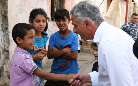 Le conseiller fédéral Didier Burkhalter partage un moment avec les enfants du quartier d’Hay Al-Gharbeh au Liban. © DFAE