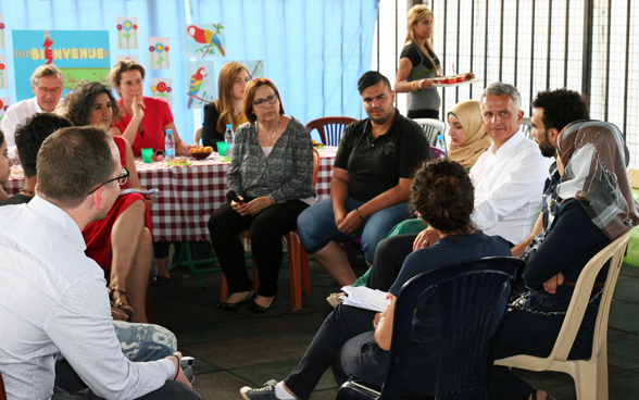 Il consigliere federale Didier Burkhalter parla con i giovani in un quartiere svantaggiato di Beirut delle condizioni di vita difficili, dei bisogni e delle prospettive per il futuro. © DFAE