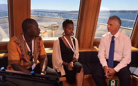 Le conseiller fédéral Didier Burkhalter échange avec Ibrahim Koroma (à gauche) et Julienne Baroni, deux anciens enfants soldats, après le tournage d’un film, lundi 23 août à Genève.