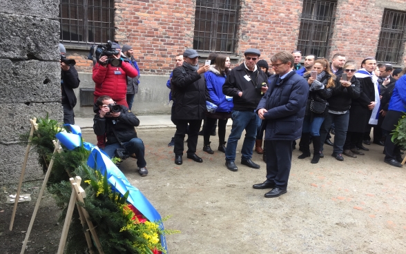 Benno Bättig, président en exercice de l’Alliance internationale pour la mémoire de l’Holocauste (HRA), se recueille devant le « mur de la mort » à Auschwitz, au pied duquel il vient de déposer une couronne de fleurs à l’occasion de la Marche des vivants.