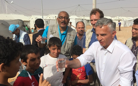 Didier Burkhatlter teilt ein Glas Wasser mit den Kindern des Flüchtingslagers von Azraq in Jordanien