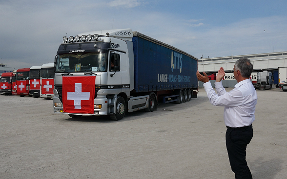 Federal Councillor Didier Burkhalter applauds as the Swiss humanitarian convoy sets off.